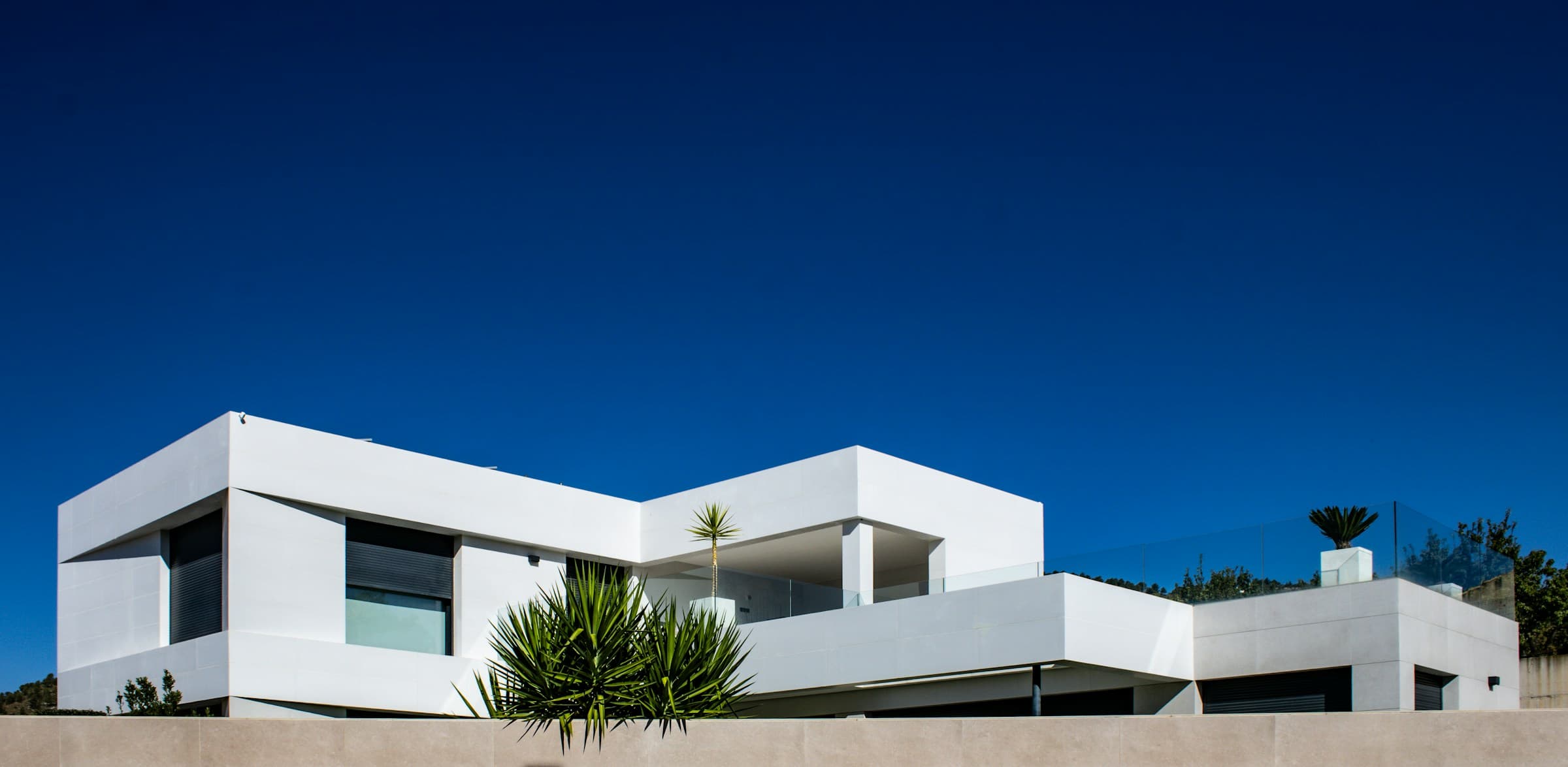 Maison contemporaine blanche sous un ciel bleu profond