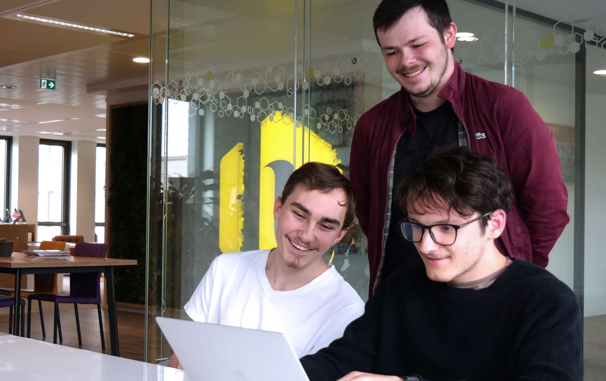 Trois étudiants travaillant ensemble devant un ordinateur portable